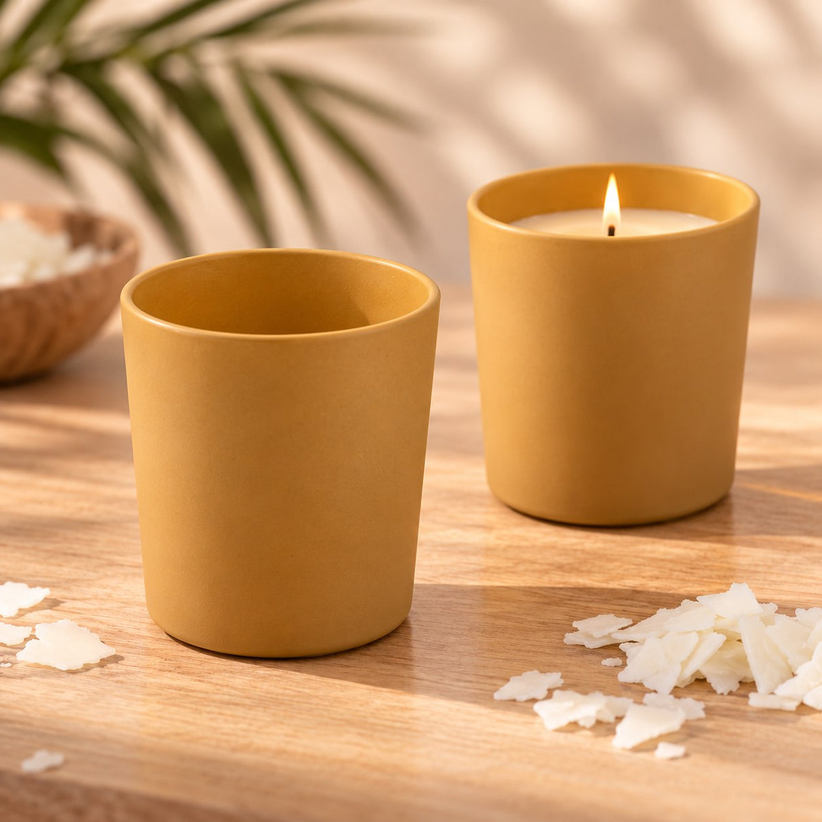 Vasos para velas beige opaco, uno vacío y otro con vela de soja encendida