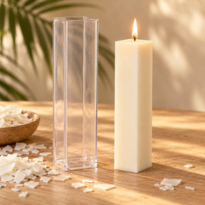 Molde de plástico transparente para velas altas cuadradas junto a una vela de pilar cuadrada encendida - Naturcera