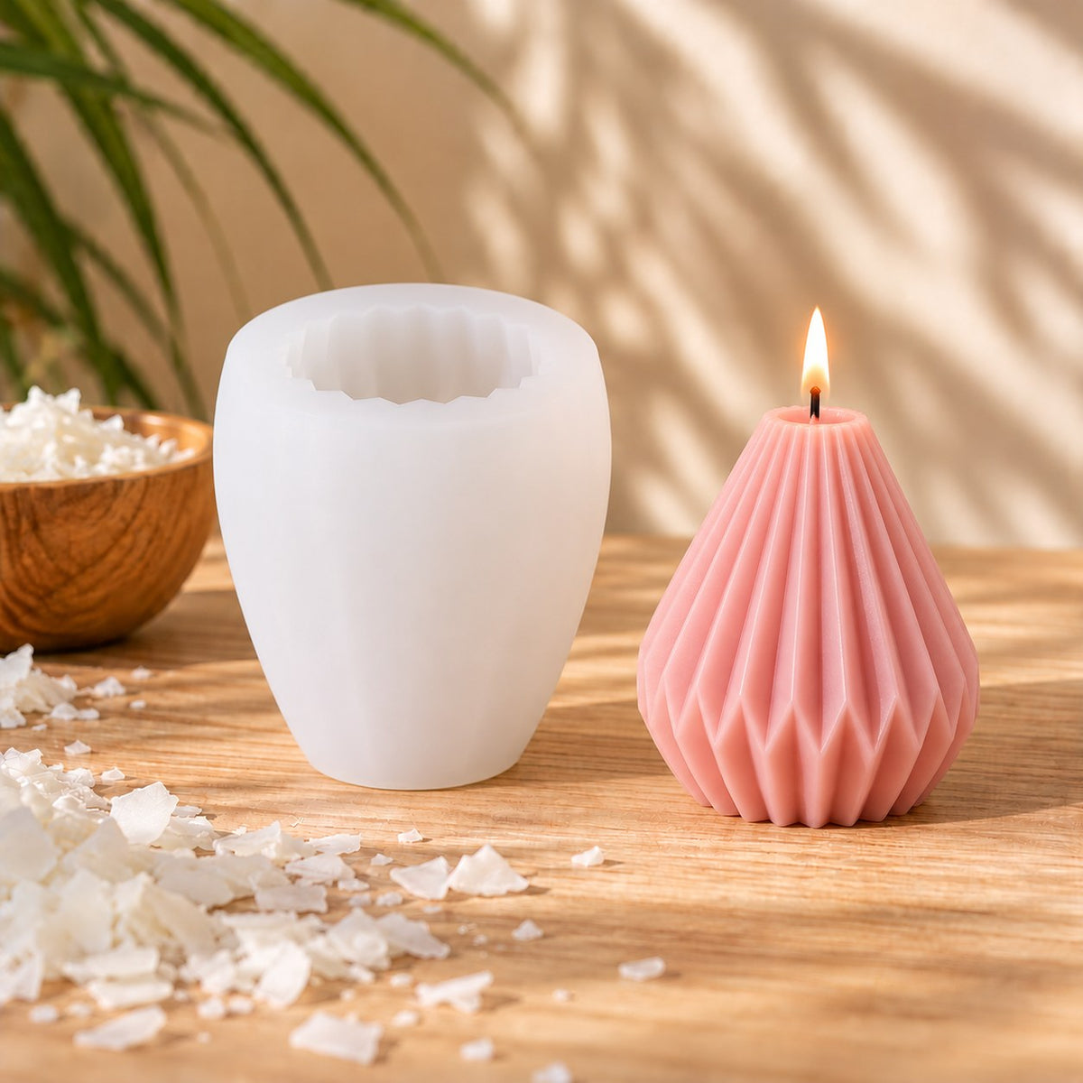 Molde de silicona con diseño plegado tipo origami y vela rosa encendida - Naturcera